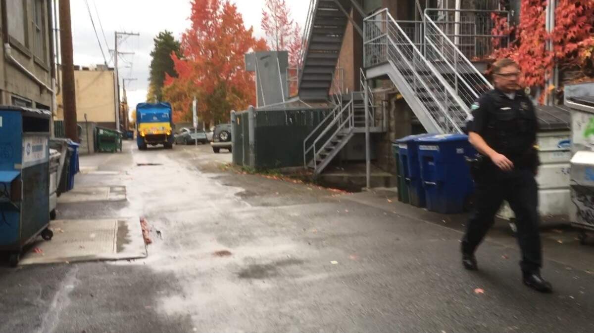 A Bellingham Police officer walks down a downtown alley Thursday afternoon as police search for a suspect who allegedly robbed the KeyBank on State Street. Officers identified the suspect as Brandon Allan Breaux.