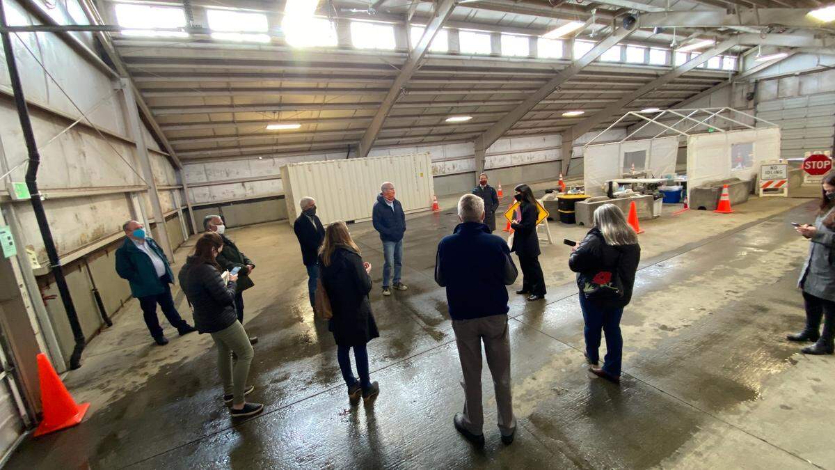 Rep. Rick Larsen, D-Everett, center in the orange mask, discusses COVID-19 vaccine distribution with Whatcom County Executive Satpal Sidhu, Lyden Mayor Scott Korthuis and Whatcom Health Department officials at the drive-up testing site at the Northwest Fairgrounds on Monday, Dec. 14, in Lynden.