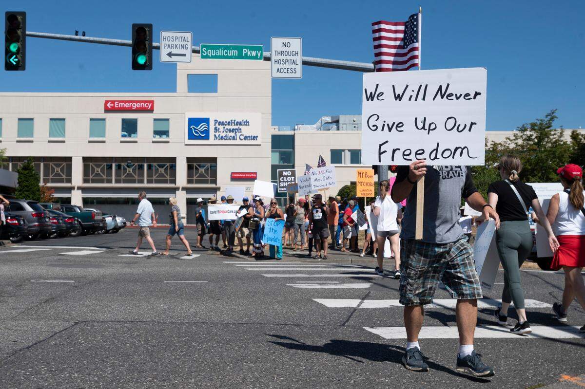 People protest the mandatory vaccination of medical workers against COVID-19 near St. Joseph hospital on Wednesday, Aug. 11, in Bellingham.