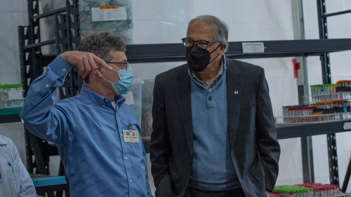 Washington state Gov. Jay Inslee listens to Dr. Greg Wolgamot, a pathologist at Northwest Laboratory, during a visit to the facility that does COVID-19 testing on Tuesday, Oct. 12, 2021, in Bellingham, Wash.
