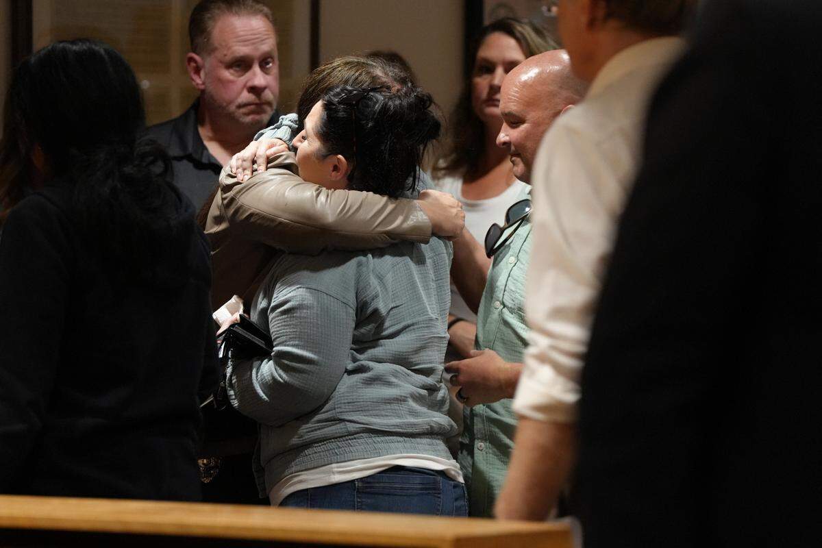 The wives of retired Whatcom County Sheriff’s deputies Ryan Rathbun and Jason Thompson share a hug after Joel Young, the man who shot both of the deputies in the head in 2022, was convicted of two counts of attempted second-degree murder.