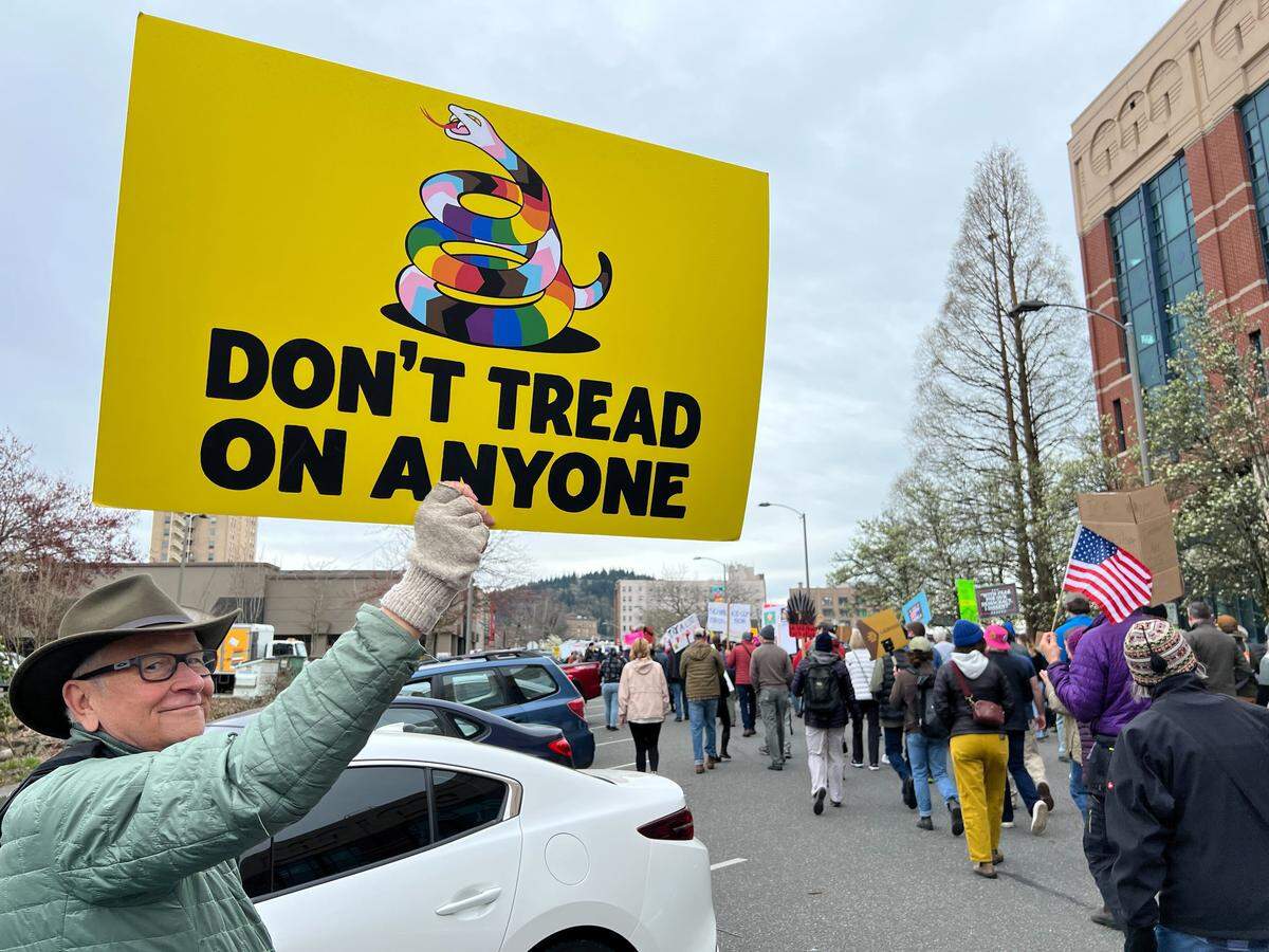 Jim Kosa of Bellingham holds up a sign during a No Kings protest Saturday in Bellingham.