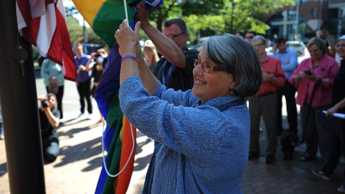 Bellingham Mayor Kelli Linville raises the rainbow-colored pride flag, placed below the American flag in Bellingham in 2013. She announced Tuesday that she won’t seek a third term.