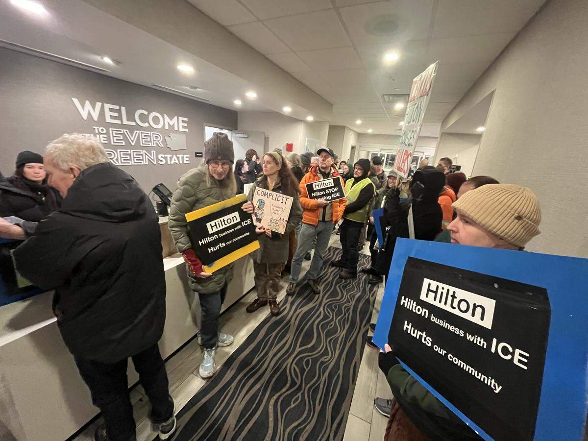 Dozens of community members gathered at the Hampton Inn Bellingham Airport on Friday night to demand that Hilton Hotels stop housing U.S. Immigration and Customs Enforcement (ICE) agents.