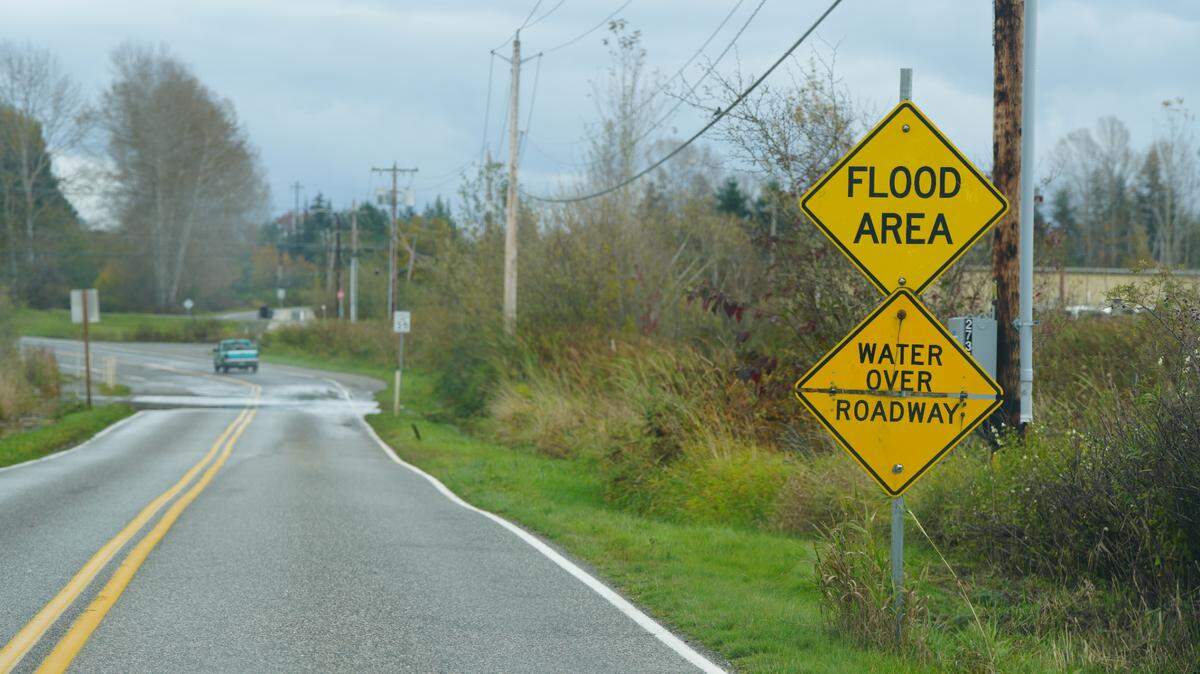 A sign notifies drivers that they are in a flood area and water is collecting on the road on Oct. 21 in Ferndale.