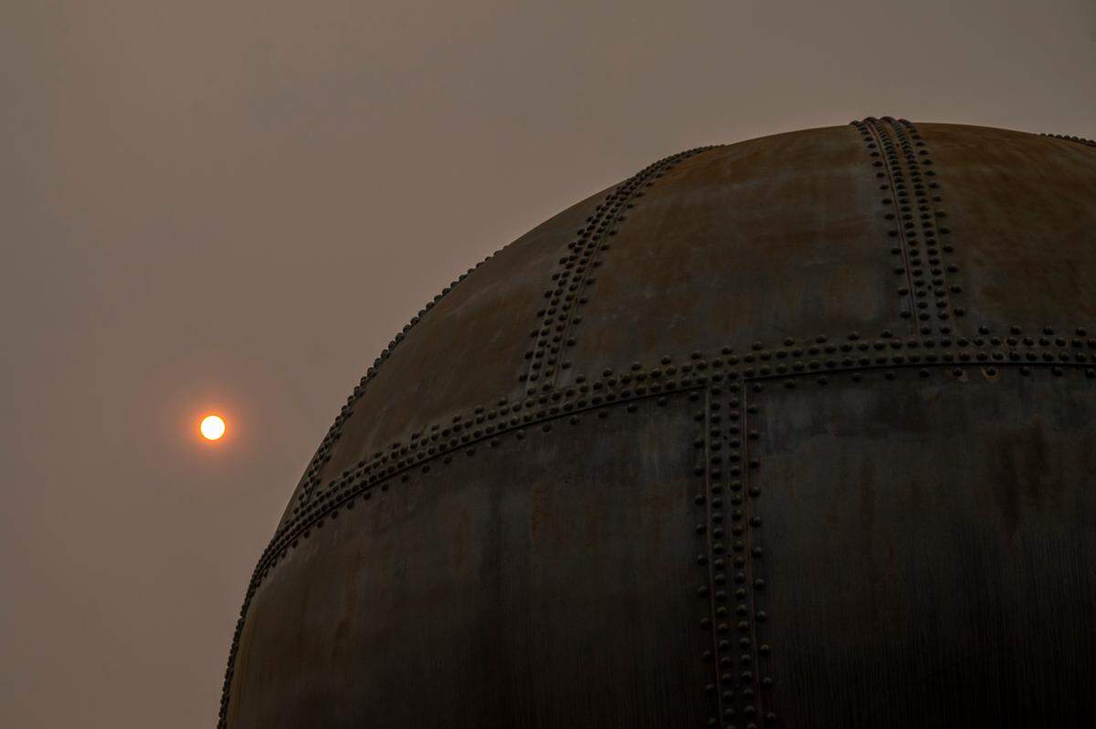 An orange sun, caused by smoke from wildfires in the U.S., is visible behind the Acid Ball at Waypoint Park on Aug. 13, 2021, in Bellingham. The American Lung Association gave Whatcom County a failing grade for its air quality and ranked it in the bottom 25 in the U.S. for daily particulate matter.