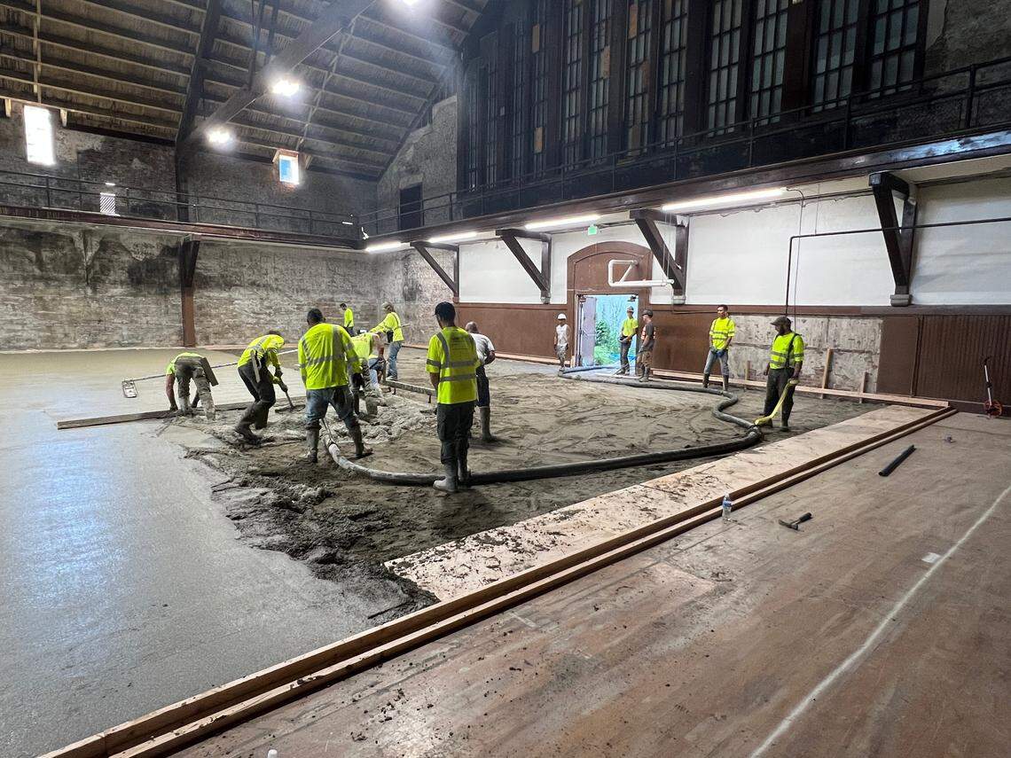 Workers from Dawson Construction and LangCo Northwest resurface the main floor of the Bellingham Armory building Tuesday, July 26. The main floor will be home to five pickleball courts.