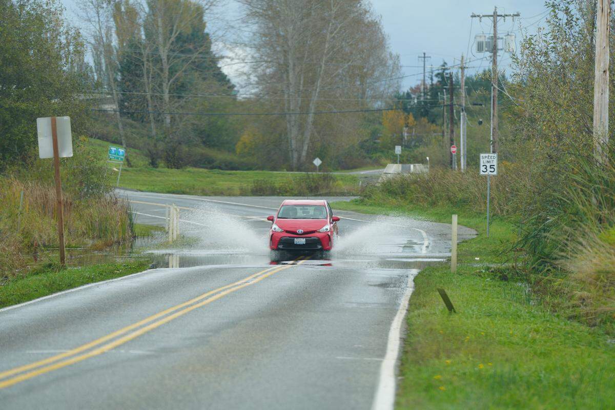 A car drives through roadway flooding last year in Ferndale after an atmospheric river moved through Whatcom County.