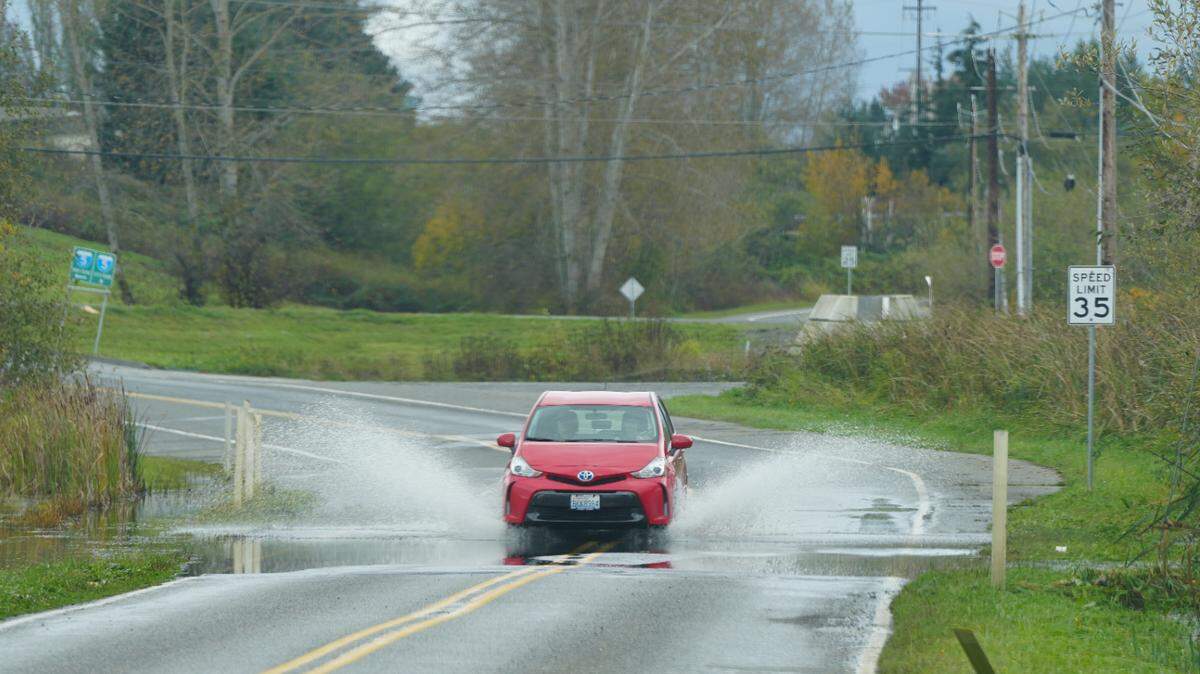 A car drives through roadway flooding on Oct. 21 in Ferndale, after an atmospheric river moved through Whatcom County.