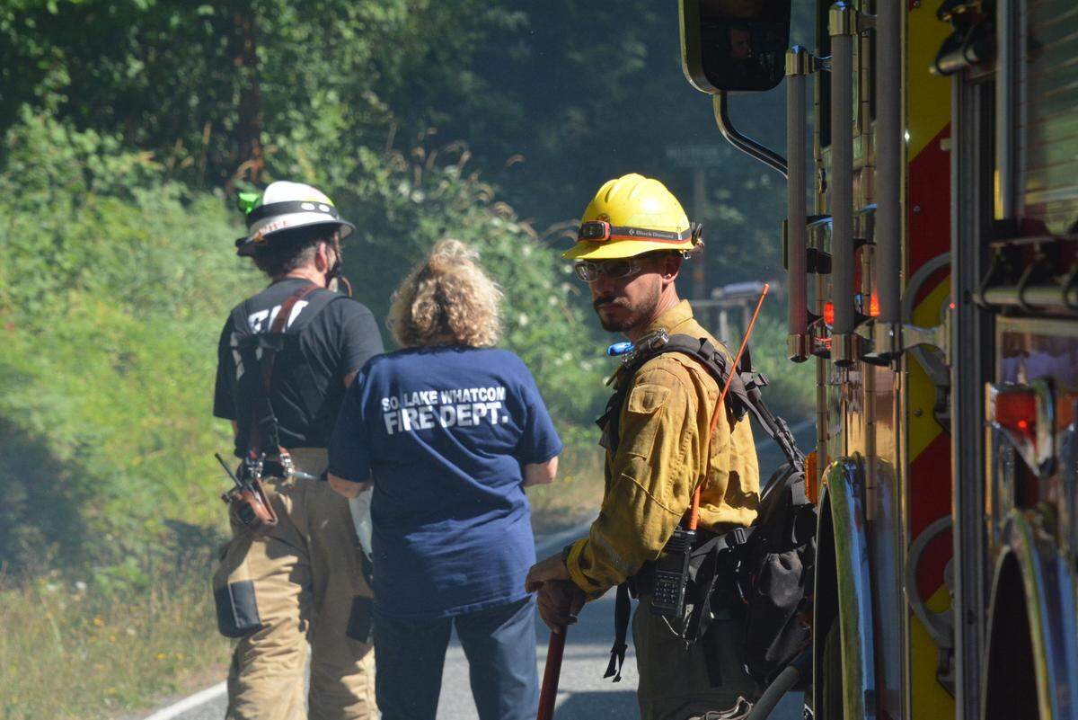 Firefighters from Whatcom County Fire District 18 and the state Department of Natural Resources are shown at the scene of a wildfire at Stimpson Family Nature Reserve east of Bellingham, Wash., on Monday, Aug. 14, 2023.