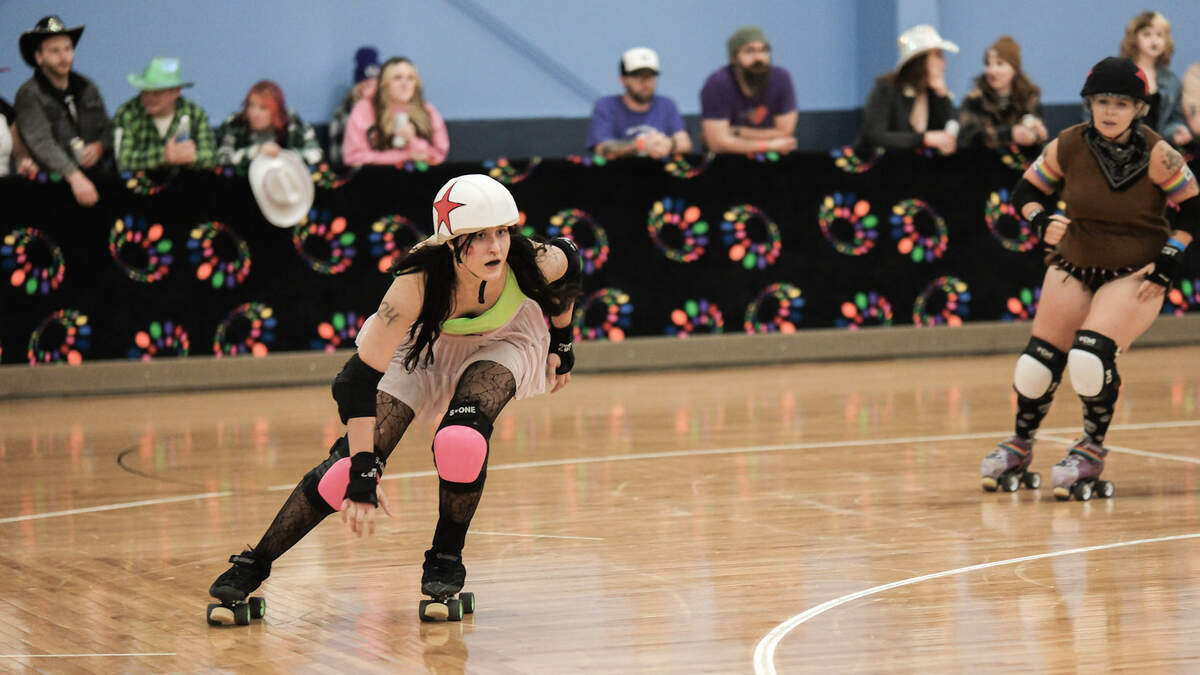 Hailey LeRoy, 2026 summer reporting intern for The Bellingham Herald, dons pink knee pads while skating for the Bellingham Roller Betties.