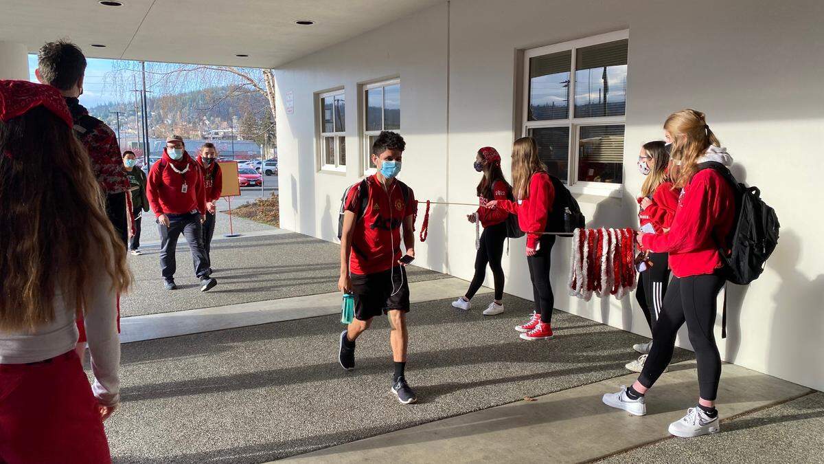 A student arrives for in-person classes while other classmates cheer them on at Bellingham High School on Friday, March 26.