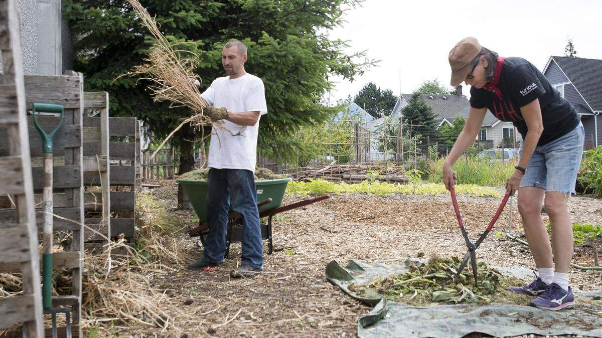 York Community Farm founder Mary Loquvam, right, and intern Gregory Irons prepare materials for compost at the farm in Bellingham in 2016.