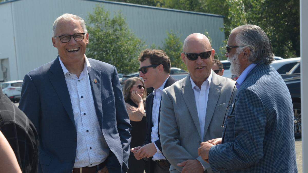 Washington Gov. Jay Inslee, left, Vicinity Motors CEO William Trainer and Whatcom County Executive Satpal Sidhu chat during a ceremonial groundbreaking for a new electric bus plant in Ferndale on Friday, July 9. All three men said in their remarks that the plant will bring family-wage jobs to Whatcom County and help fight global climate change.