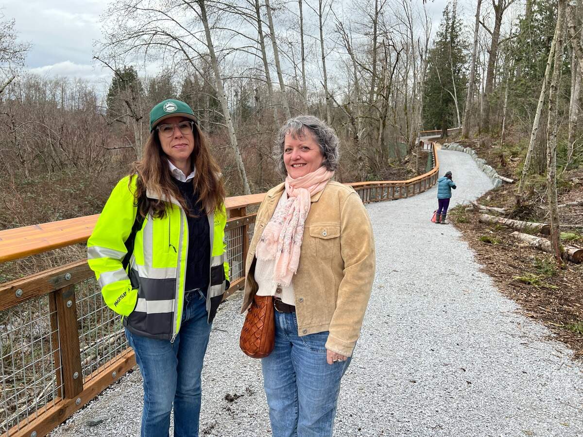 Nicole Oliver, director of the Bellingham Parks and Recreation Department (right) and parks project engineer Gina Austin walk a new trail at Sunset Pond on Wednesday in Bellingham.