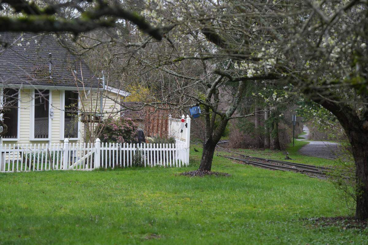 A rail spur used by Bell Lumber & Pole is seen between a residential home and a pedestrian trail on March 17 in Bellingham. This house is one of many located adjacent to a Heavy Impact Industrial (HII) zoning area in an Urban Growth Area (UGA) of Whatcom County.