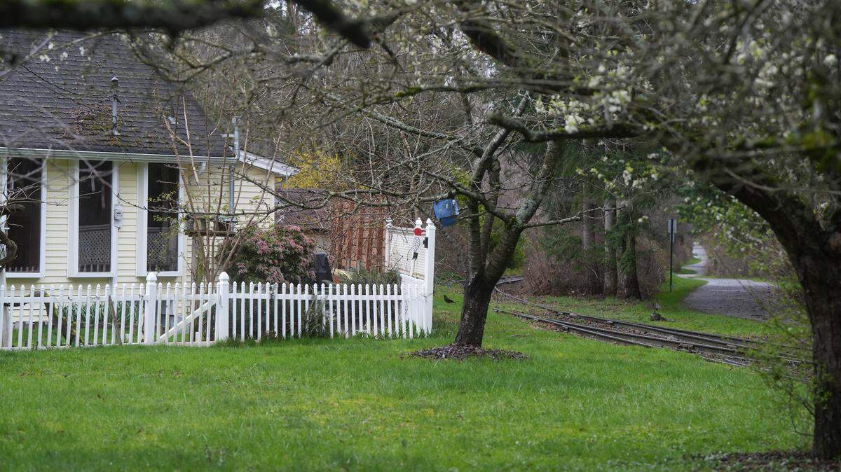 A rail spur used by Bell Lumber & Pole is seen between a residential home and a pedestrian trail on March 17, 2026, in Bellingham, Wash. This house is one of many located adjacent to a Heavy Impact Industrial (HII) zoning area in an Urban Growth Area (UGA) of Whatcom County.