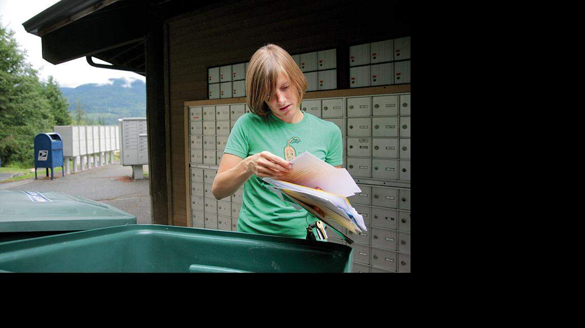 Emily Dickinson, who moved to Whatcom County last November with her husband, sorts through her mail at the Sudden Valley mailbox rotunda. Residents often bump into each other at the eight-sided building, through which nearly 75 percent of Sudden Valley residents get their mail.