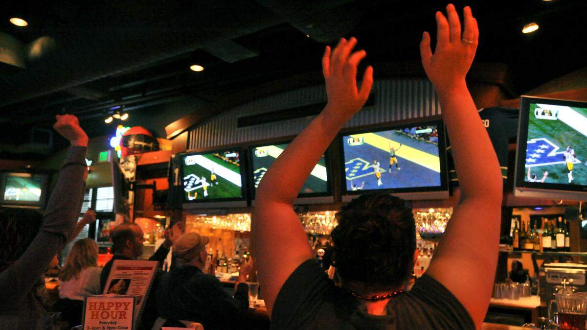 Jenn Noland, right, and other fans celebrate as the Greenbay Packers score their first touchdown of Super Bowl XLV Sunday afternoon, Feb. 6, at Boston’s restaurant in Bellingham. The Packers went on to win the game 31-25.