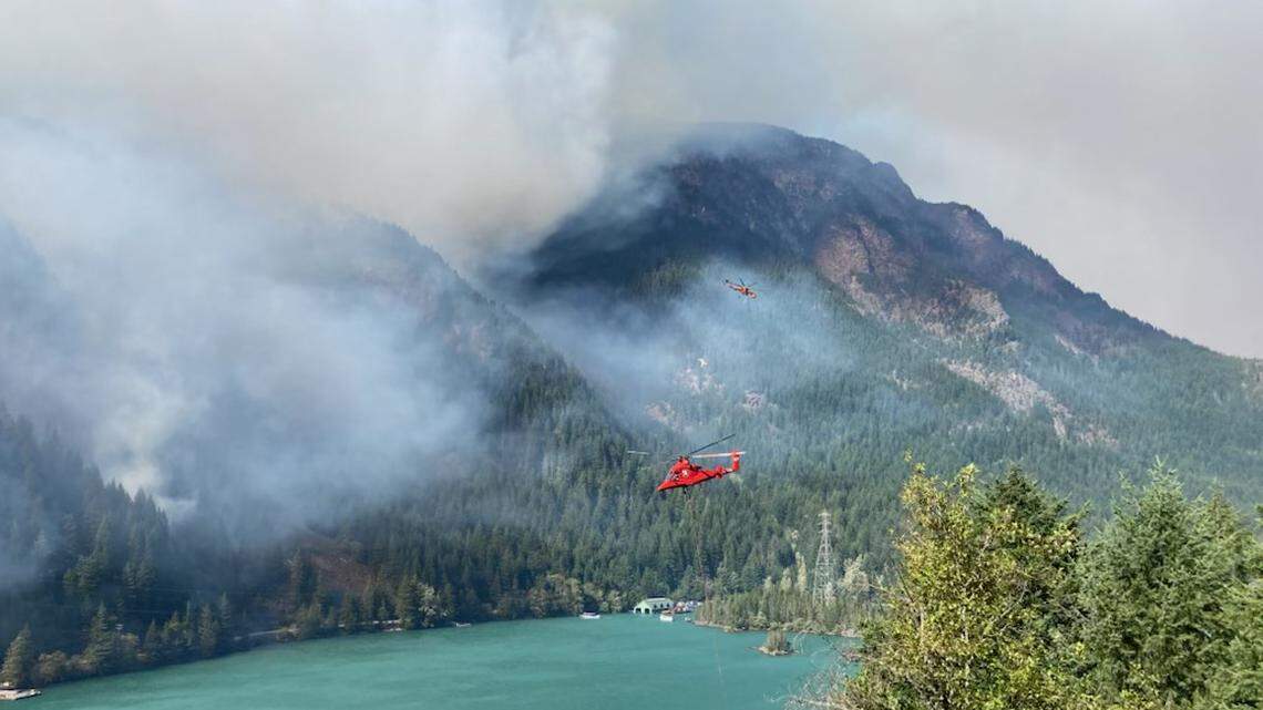 Helicopters are making water drops to fight a wildfire on Sourdough Mountain above Diablo Lake in western Whatcom County.
