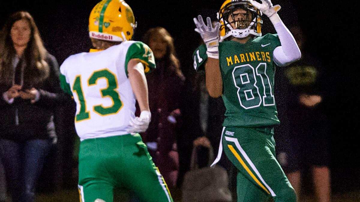 Sehome wide receiver Andre Watson (81) catches a long pass as Lynden defensive back Harrison Joss (13) moves in for the tackle during the fourth quarter on Friday evening Oct. 15, at Civic Field in Bellingham. With a gain of over 40 yards, Watson’s catch helped set up a Sehome score the following play. The Lynden Lions defeated the Sehome Mariners 23 to 7.