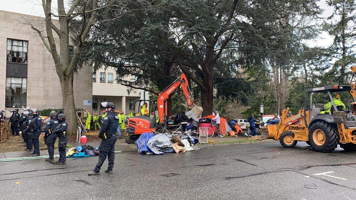 Police and city crews clear the Camp 210 homeless encampment from the City Hall and library lawns on Lottie Street in downtown Bellingham, Wash., Thursday, Jan. 28, 2021.