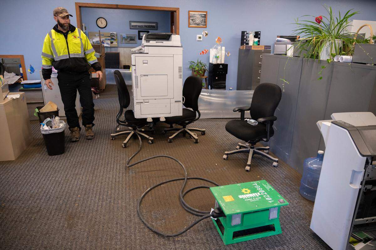 Mayor Kyle Christiansen assesses damages inside Sumas City Hall after flood waters receded from a storm on Friday, Nov. 19.