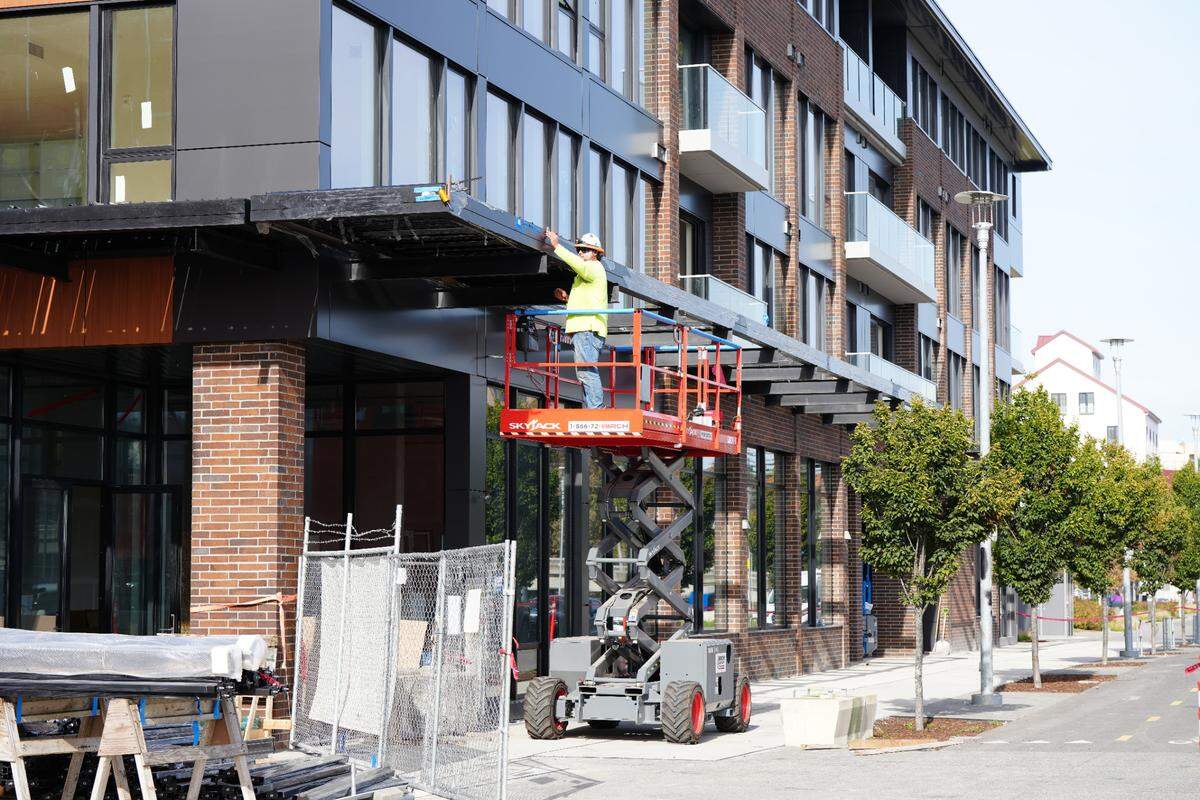 A worker is seen outside the first of three multi-million dollar residential condo buildings under construction along the waterfront on October 3, 2024, in Bellingham, Wash. The first building was nearing completion while the other two still had significant work to be done.