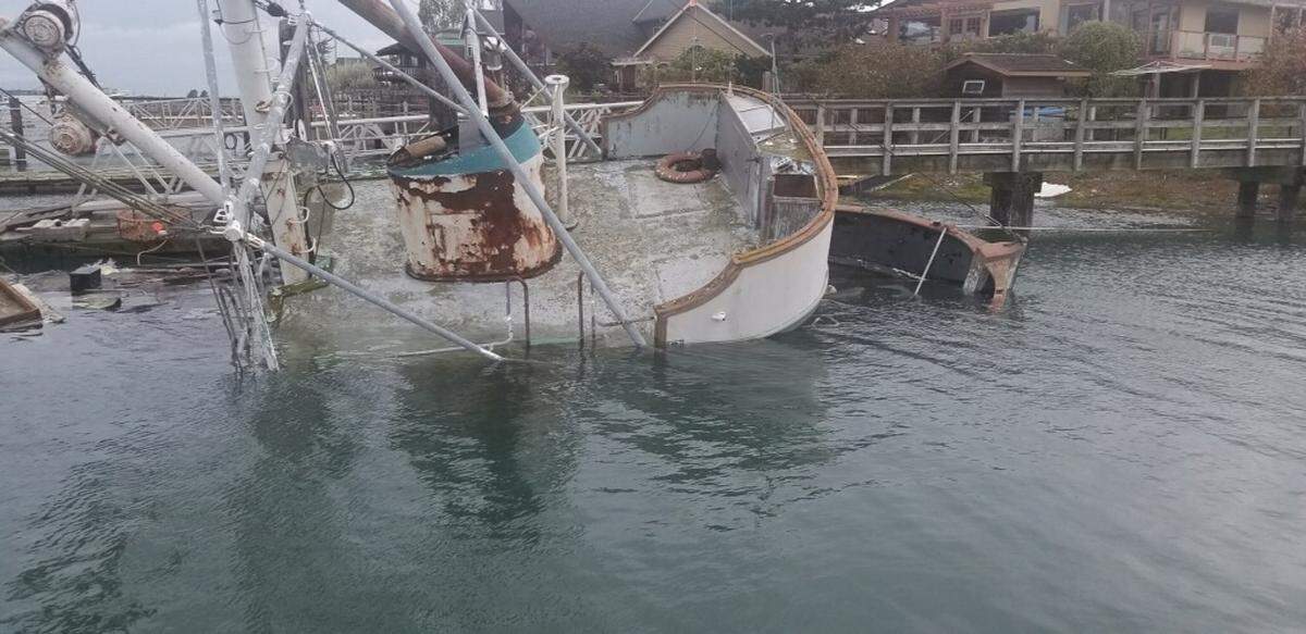 The F/V Furious Sea takes on water while tied to a dock in the channel at Sandy Point on Thursday. Behind the Furious Sea are the remains of the F/V Coral Sea, which sank in 2016.