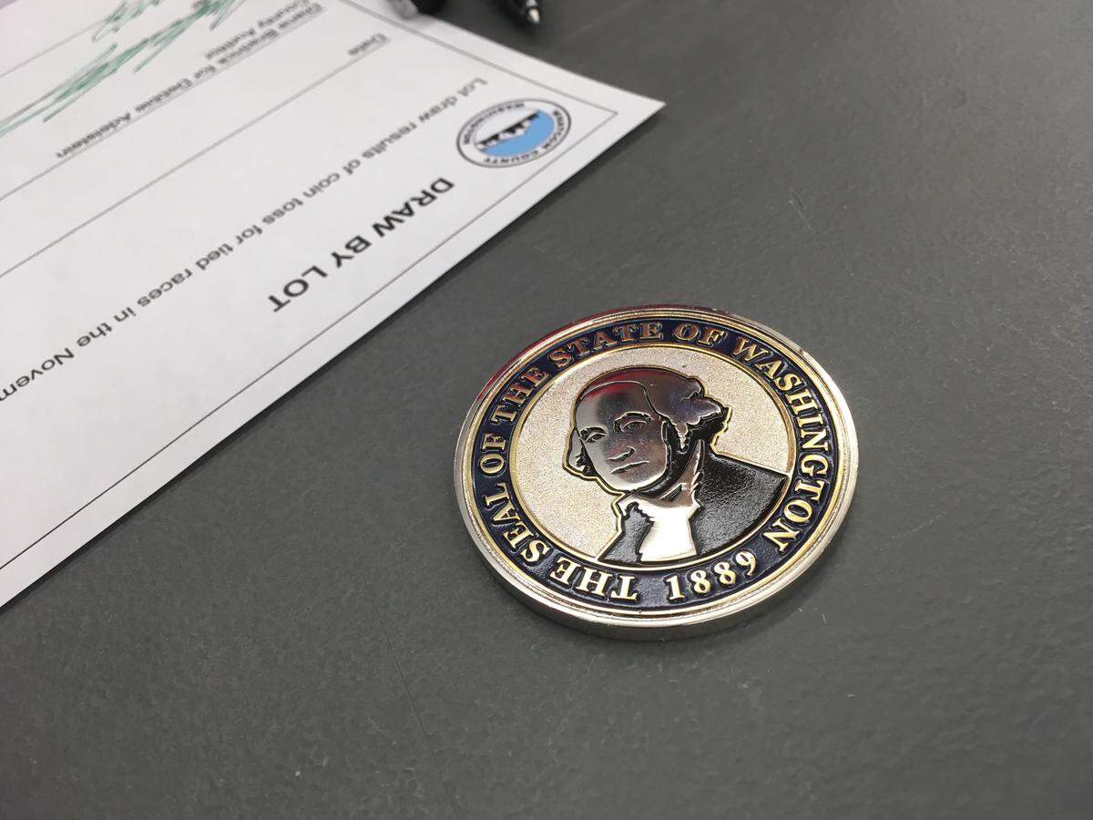 Deborah Morgan of Sumas and Paul Shuey of Ferndale won council seats in a toss of a commemorative “challenge coin” from Secretary of State Kim Wyman Wednesday in Bellingham.