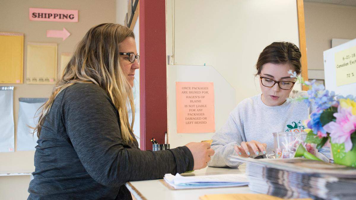 Canadian citizen Colleen Jeffrey, left, is helped by Hagen’s of Blaine employee Kelsey Freeman while picking up packages Thursday in Blaine.
