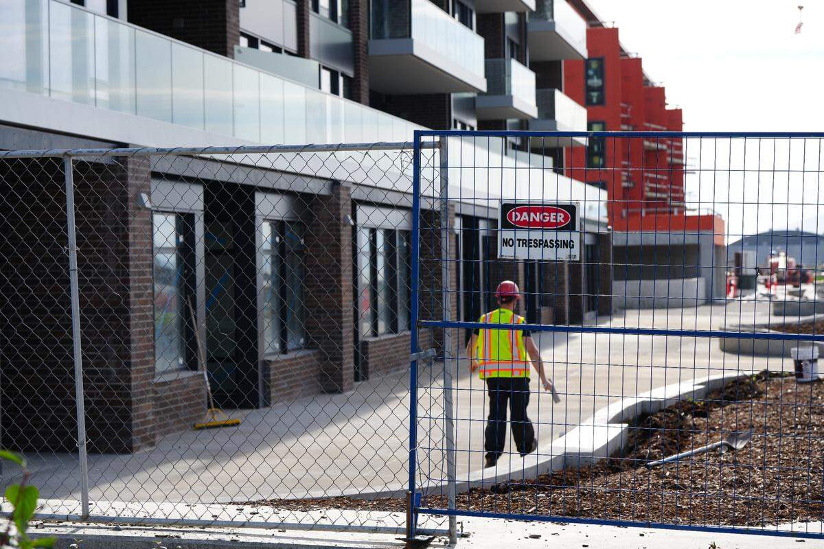 A worker is seen outside one of three multi-million dollar residential condo buildings under construction along the waterfront on October 3, 2024, in Bellingham, Wash. The first building was nearing completion while the other two still had significant work to be done.