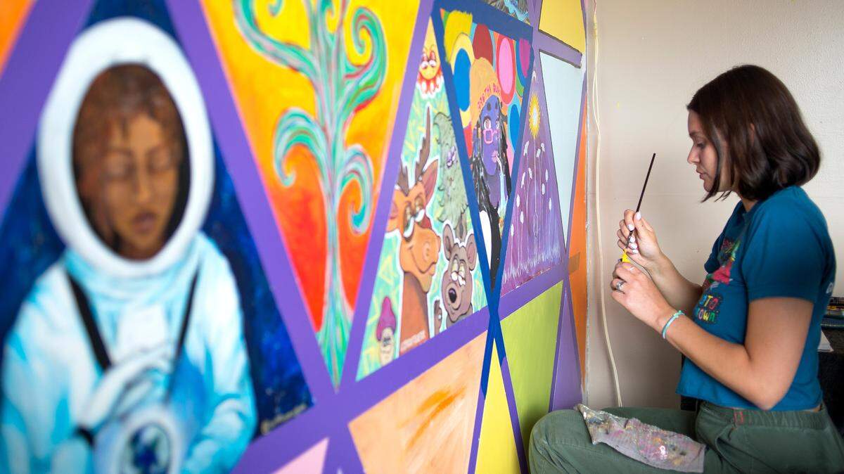 Olivia Falls, an employee at Brotha Dudes: The Kick-Back, paints part of a mural on the restaurant wall on Thursday in Bellingham. The mural is a work-in-progress featuring contributions from Brotha Dudes employees and local artists.