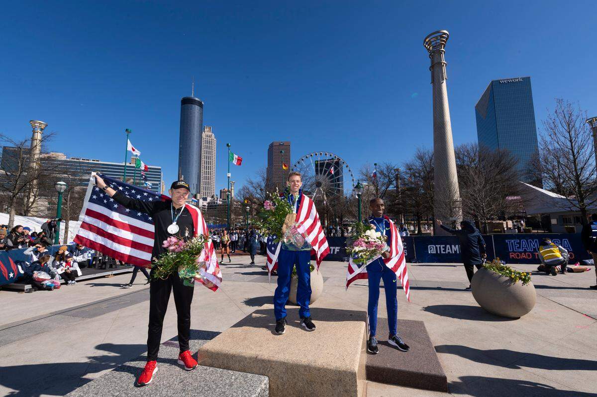 First-place finisher Galen Rupp, center, second-place finisher Jacob Riley, left, and third-place finisher Abdi Abdirahman stand on the medal stand in Centennial Olympic Park after running in the U.S. Olympic marathon trials, Saturday in Atlanta. Riley graduated from Sehome High School.
