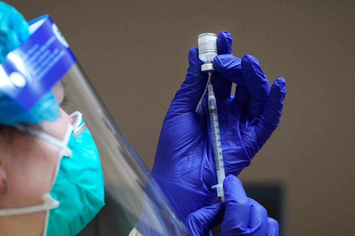 Registered nurse Michelle O’Brien prepares a COVID-19 vaccination Thursday, Dec. 17, at the Chinook Clinic on the Lummi Reservation, near Bellingham. Lummi Nation began rationing its first 300 doses of vaccine as it fights surging cases with a shelter-in-place order.