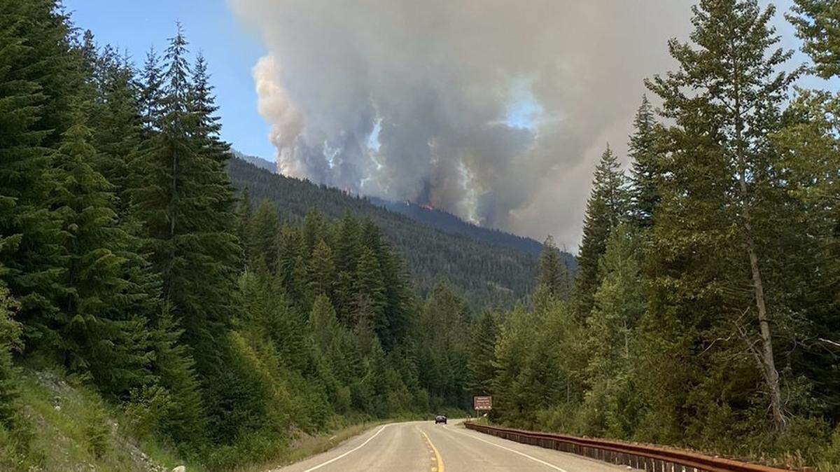Smoke rises from a fire west of Winthrop, Wash., along Highway 20 on Monday, July 12.