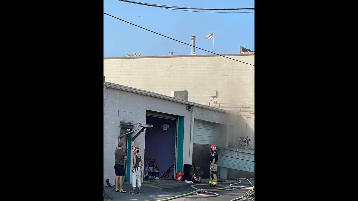 Smoke exits a garage door entrance of a building on Commercial Street around 5 p.m. on Monday, Aug. 7, in downtown Bellingham, Wash.
