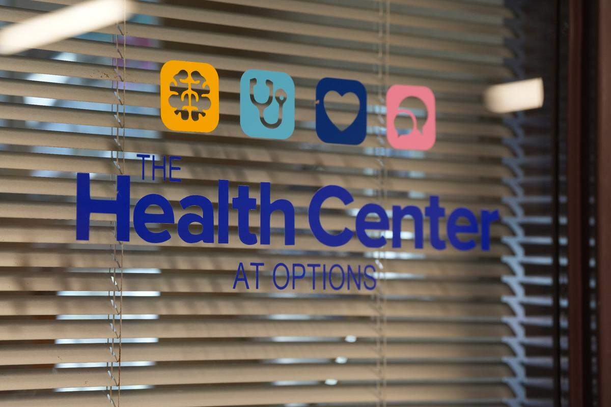 A sign indicates Option High School’s new health center available to students for both medical and behavioral services.