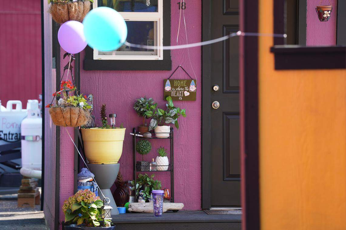 A tiny home in the North Haven village is decorated with plants and a sign.