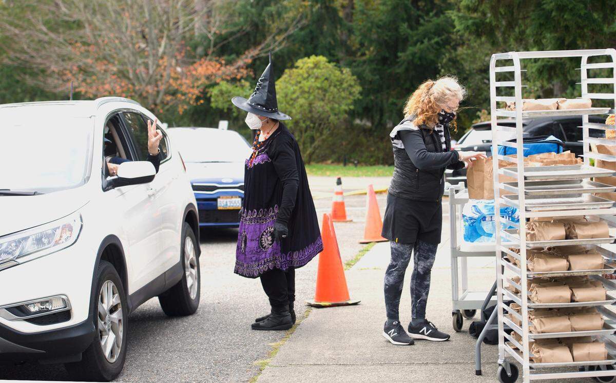Volunteers for the Whatcom Council on Aging distribute meals to seniors on Wednesday, Oct. 28, 2020, in Bellingham, Wash.