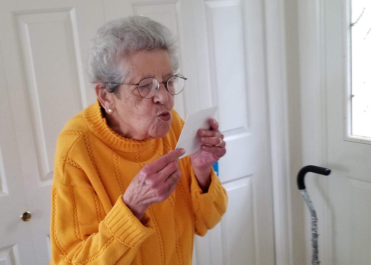 Noémi Ban, 96, blows kisses at a thank-you letter she received from her great-granddaughter in Maine in her Bellingham home in 2018, before her death June 7 after a brief illness.