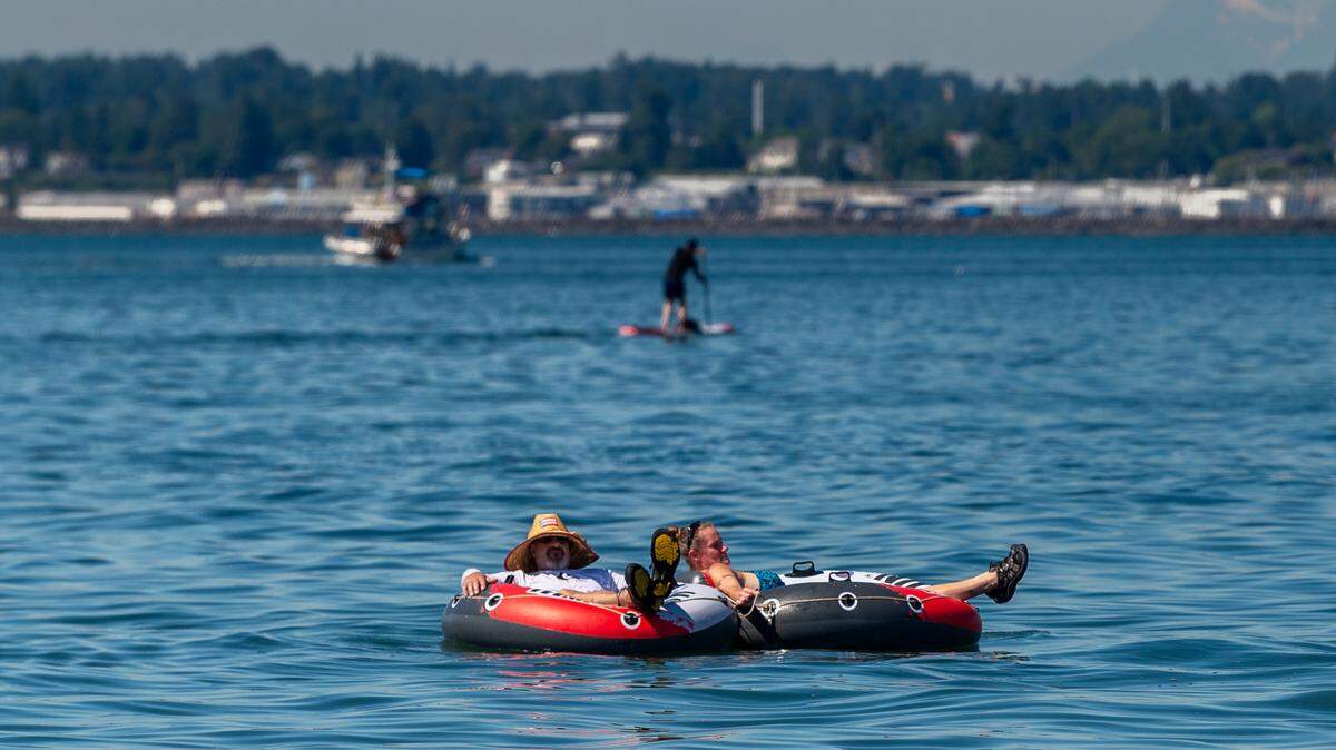 William Toensing and Angela Hendrickson float in Bellingham Bay to attempt to escape the oppressive heat at Taylor Dock in Boulevard Park on Saturday afternoon June 26, 2021, in Bellingham, Wash. “We have the blinds down and fans on, but wish we had air conditioning” Hendrickson said, “but we’re down here chilling out.”