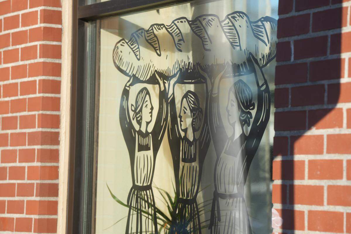 A Millet Bakery window decal depicts sisters Clara, Aemilia and Chloe, who own and operate the new bakery in Bellingham.