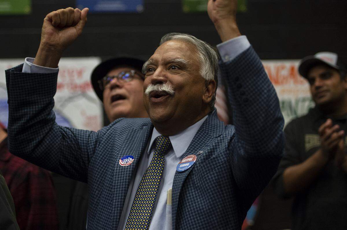 Whatcom County executive candidate Satpal Sidhu cheers as the initial numbers come up on the big screen during his election night party at the Whatcom Democrats’ office in downtown Bellingham Tuesday.