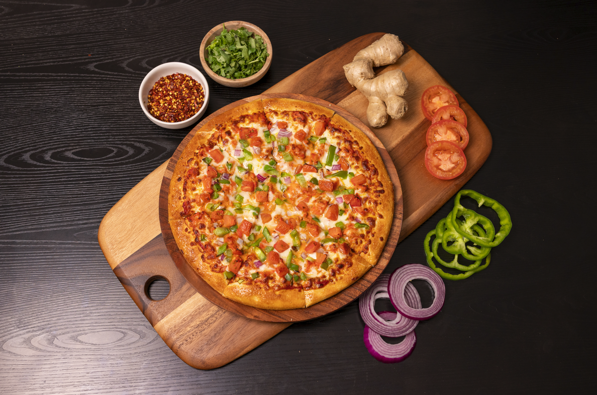 A butter chicken pizza from Can Am Pizza, opening in May 2026 at 1251 Lincoln St Suite 106, in Bellingham, Wash.
