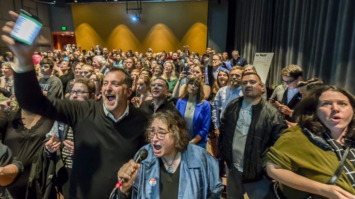 Sen. Kevin Ranker, left, Cascadia Now producer Shemaia Kountouros, and candidate Sharon Shewmake, far right, cheer as the results of the 2018 midterm elections in Whatcom County are displayed at a gathering of Democrats Tuesday evening at the Mount Baker Theatre in Bellingham.