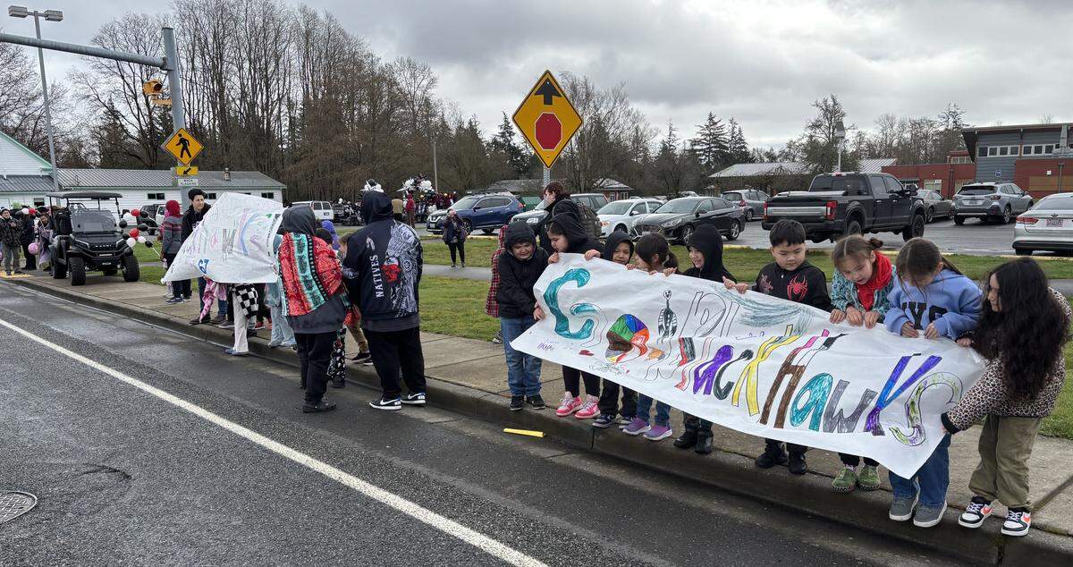Students hold up a homemade banner honoring the Lummi Nation School Blackhawks basketball teams during a parade Friday in Bellingham.