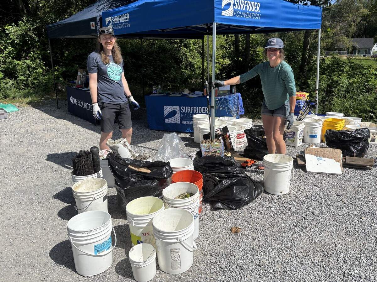 Seth Mangold (RE Sources) and Jamy Pearson (Surfrider Foundation) pose in front of trash collected from Locust Beach on July 5, 2026. Volunteers cleared about 168 pounds of debris from the beach.