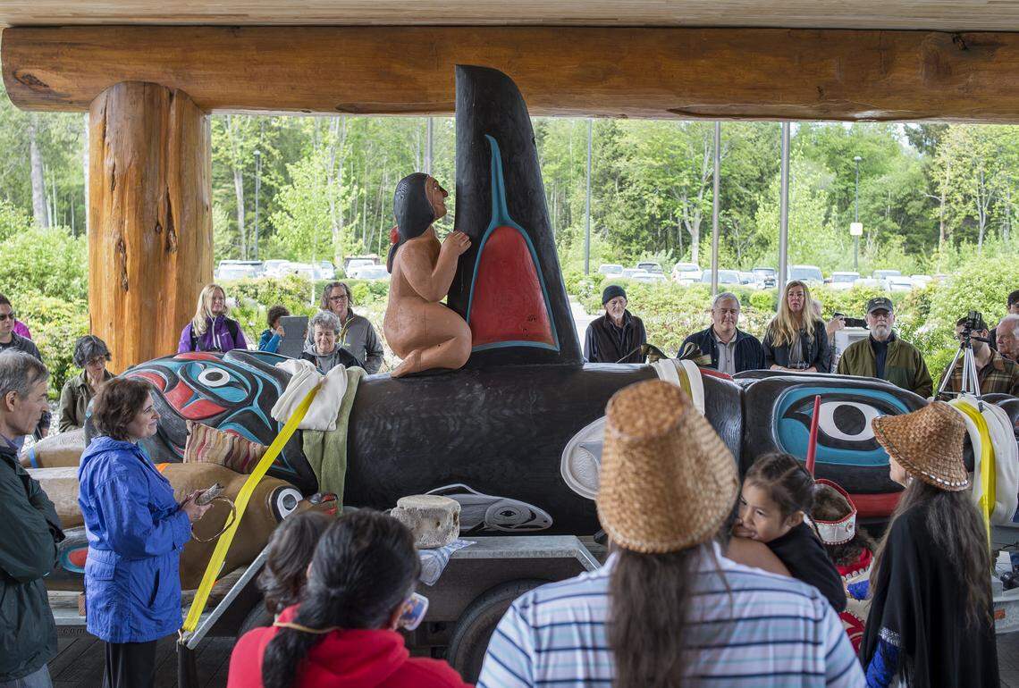 People gather around a 16 1/2-foot orca totem pole during the Lummi Nation stop of the Tokitae Totem Pole Journey 2018 on Thursday, May 10, at the Lummi Nation Tribal Administration Center north of Bellingham. The orca totem pole, and two accompanying seal poles, were carved by Jewell James and the House of Tears carvers and are being trucked to Miami in an effort to free Tokitae, a killer whale.  Known as Lolita at the Miami Seaquarium where she has lived for more than 47 years, she is the last survivor of the more than 50 orcas captured off Puget Sound on Aug. 8, 1970.