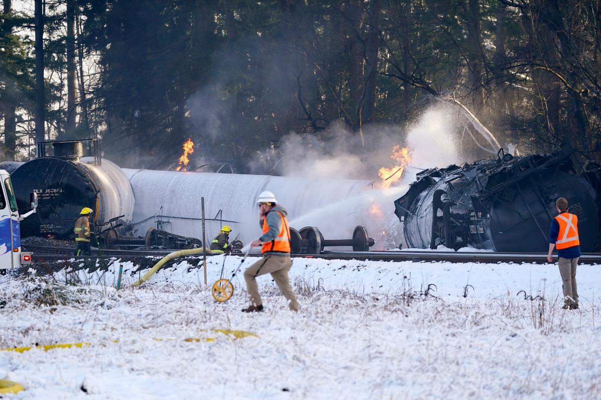 A firefighter sprays foam on a burning, derailed train car Tuesday, Dec. 22, in Custer.
